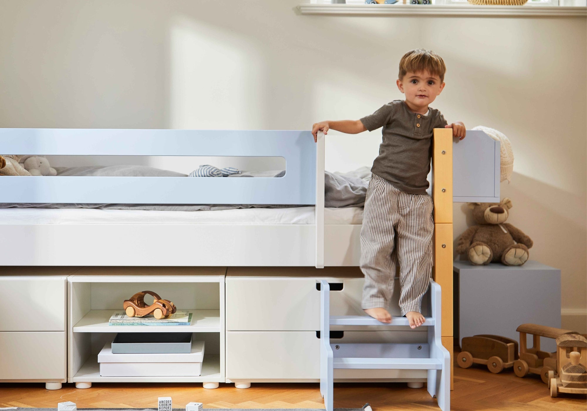 Dreng der står på en juniorseng med et stige og opbevaring