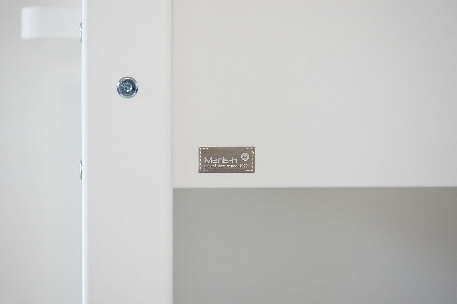 Manis-h logo medalje på hvid børnemøbel